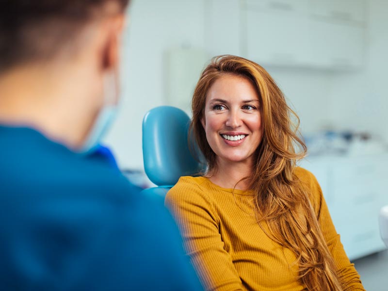 young woman sitting in chair at dentists office