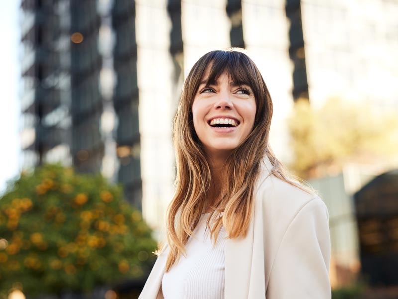 Young Professional Walks, Looking Back with a Broad Smile.