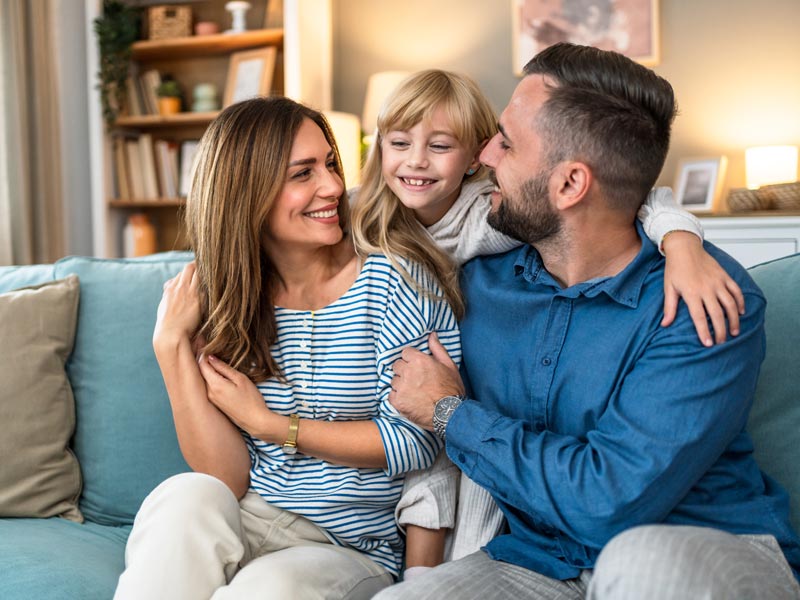 Happy parents and little daughter at home