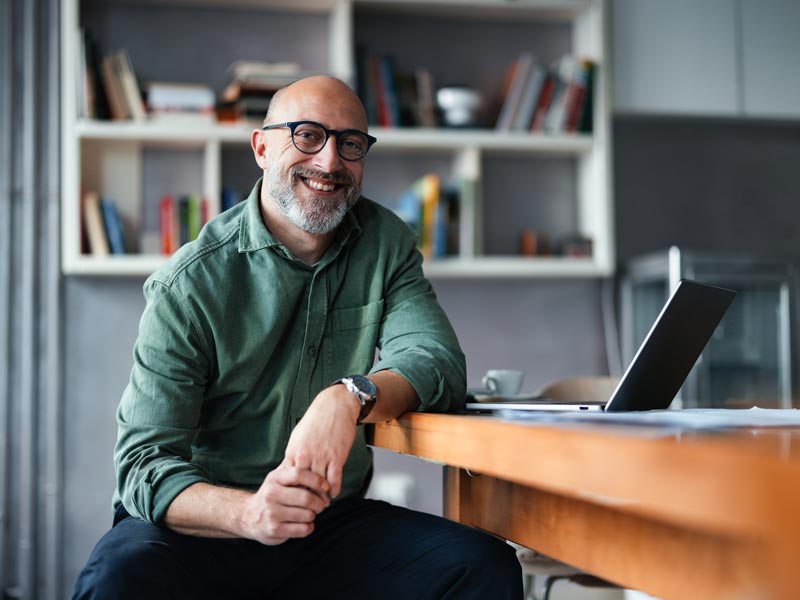 Confident Professional Man Sitting at Desk in Modern Office Space